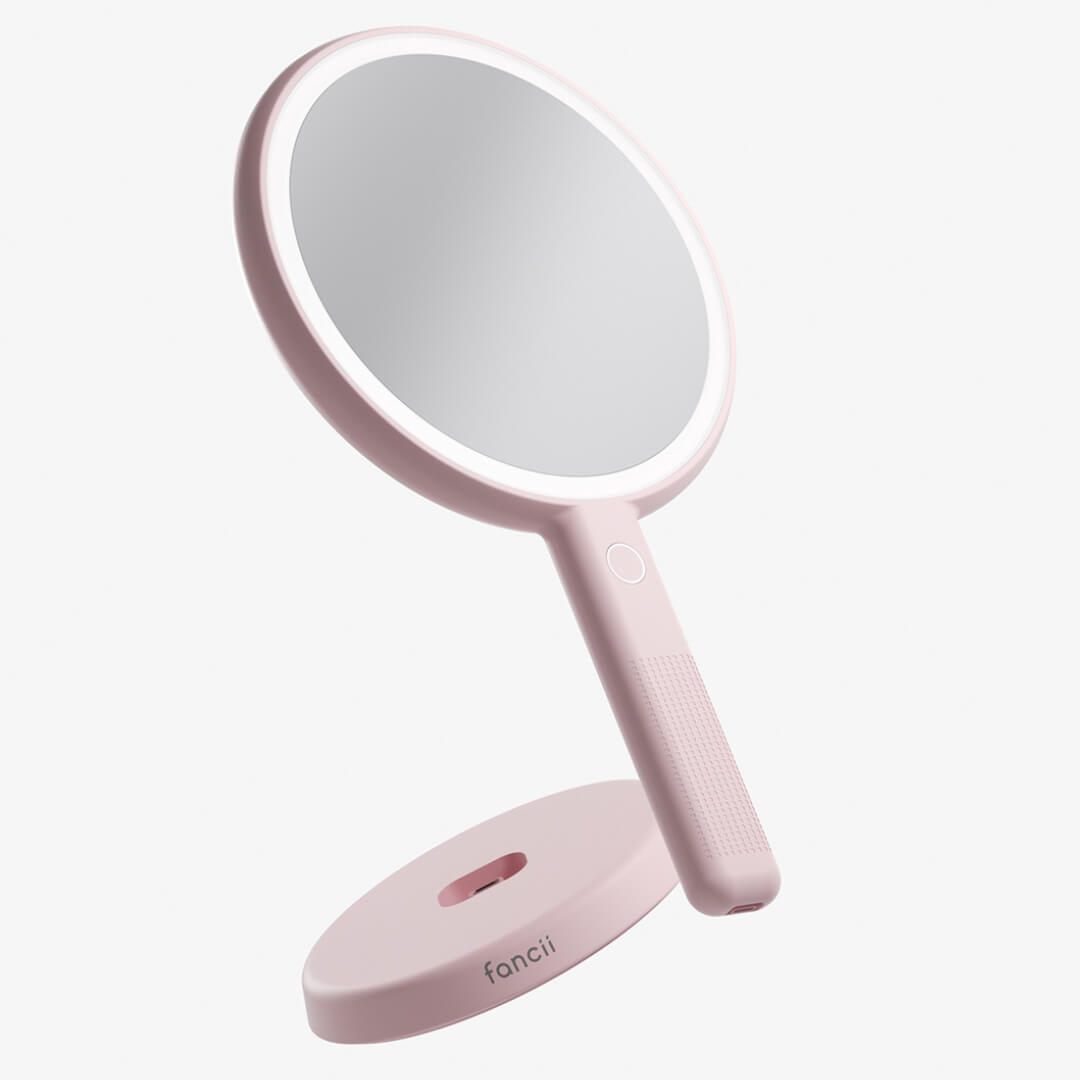 Pink Cami LED Lighted Handheld Mirror with 1x/5x magnification and vanity stand for makeup and skincare.