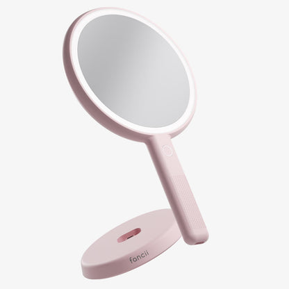 Pink Cami LED Lighted Handheld Mirror with 1x/5x magnification and vanity stand for makeup and skincare.