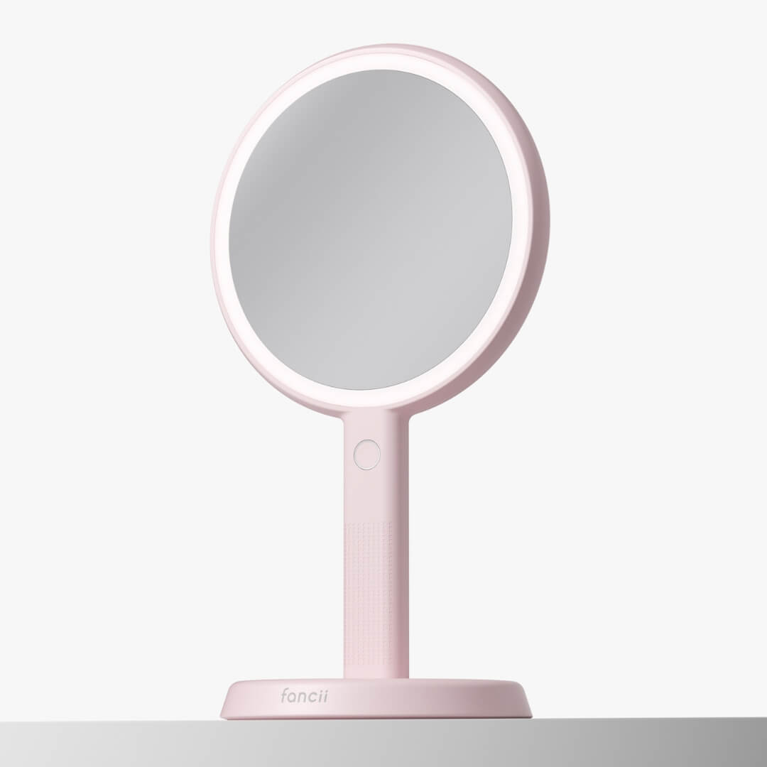 Pink Cami LED Lighted Handheld Makeup Mirror on vanity stand with 1x/5x magnification and 52 LED ring light.