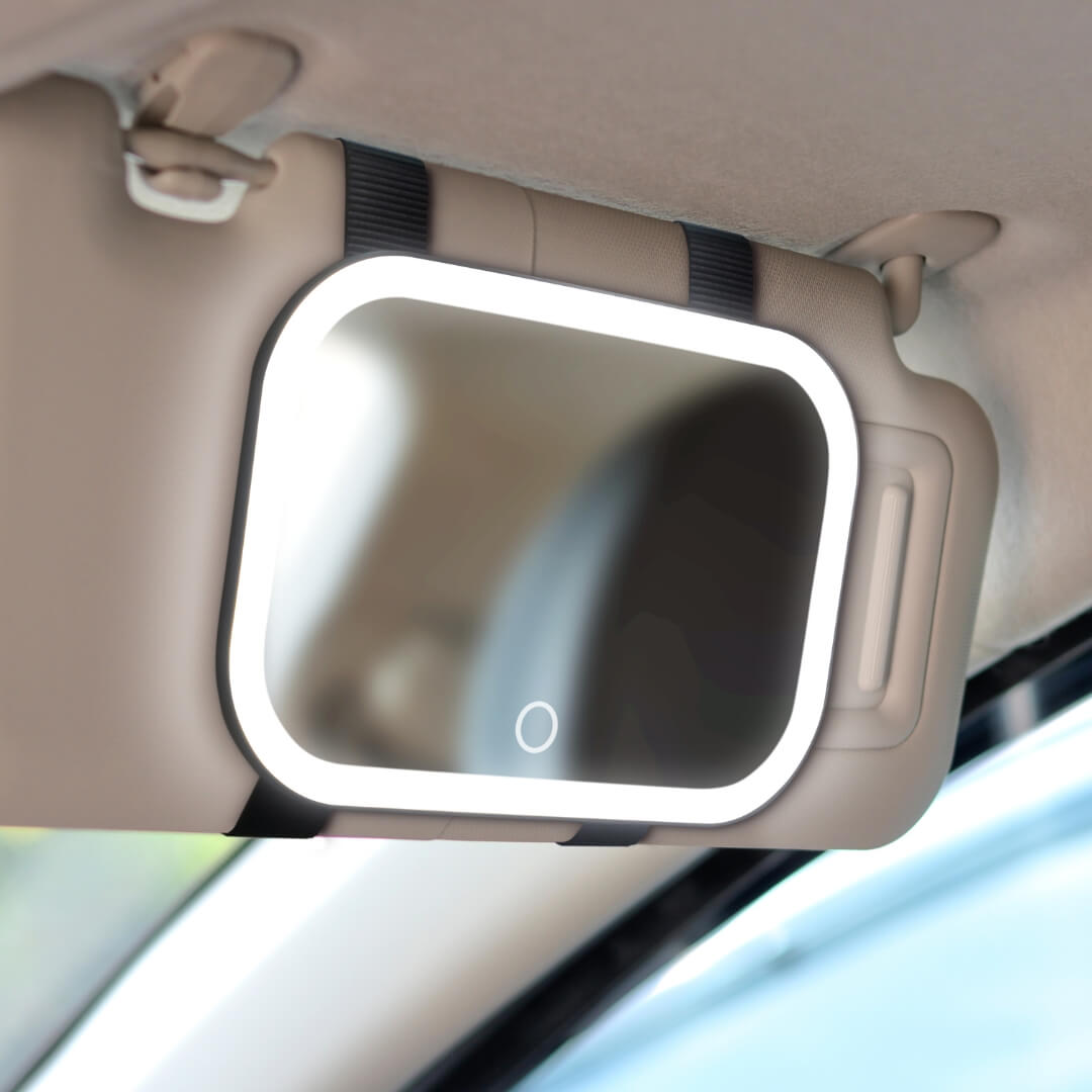 Juni 2 lighted car visor mirror with bright LED vanity lights strapped to a vehicle sun visor for travel makeup.