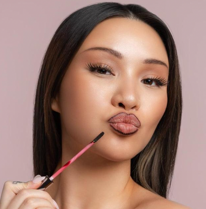 Model applying Stay-N Peel-Off Lip Liner with an applicator to create a dark, long-lasting matte outline.