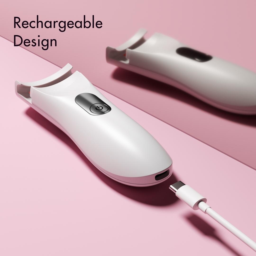 White Tasha rechargeable heated eyelash curler with USB charging cable on a pink background.