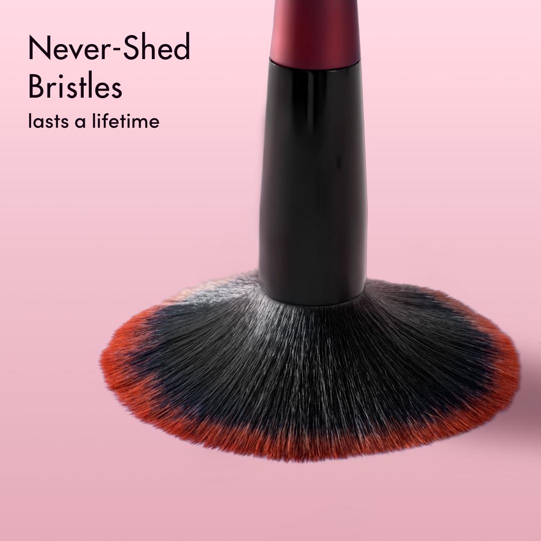 Close-up of Aria Pro makeup brush showing never-shed black and red ombre bristles for professional cosmetic application.